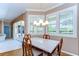 Sunlit dining room with plantation shutters, modern chandelier, and neutral color palette at 4904 Breyer Wood Ct, Valrico, FL 33596