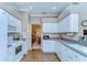 Functional kitchen featuring white cabinets, tiled backsplash, and views into the formal dining room at 4904 Breyer Wood Ct, Valrico, FL 33596
