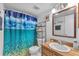 Cozy bathroom featuring decorative ocean themed shower curtain and wood-framed mirror at 808 Centerwood Ct, Brandon, FL 33511