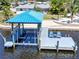 A waterfront residence features a dock with covered boat lift and comfortable seating at 810 Blue Heron Blvd, Ruskin, FL 33570