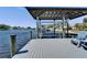 Dock with boat lift, gray decking, blue chairs, and picturesque waterfront views on a clear day at 810 Blue Heron Blvd, Ruskin, FL 33570