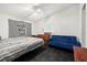 Bright bedroom featuring a patterned bedspread, a blue couch and a 