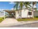 Charming single-story home with covered carport, lush lawn, and mature palm trees under a sunny blue sky at 8632 Fantasia Park Way, Riverview, FL 33578