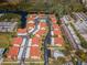 Stunning aerial view of the community showcasing the pool, landscaping, and residential buildings with red roofs at 9980 Eagles Point Cir # 1, Port Richey, FL 34668