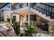 Entrance to condo with stone details, landscaped patio, and black railings at 9980 Eagles Point Cir # 1, Port Richey, FL 34668