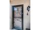 Stylish front door with a glass screen, black trim, and a decorative cross hanging on the door at 9980 Eagles Point Cir # 1, Port Richey, FL 34668