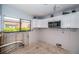 Bright kitchen featuring white cabinets, stainless microwave, and window with lush outdoor views at 9980 Eagles Point Cir # 1, Port Richey, FL 34668