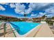 Community pool offering a refreshing oasis for residents on a sunny day with palm trees and lounging areas at 9980 Eagles Point Cir # 1, Port Richey, FL 34668
