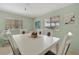 Bright dining room features a white table, modern chairs, and coastal decor at 110 E Saint Lucia Loop, Apollo Beach, FL 33572