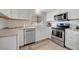 A well-lit kitchen showcases white cabinets, stainless steel appliances, and neutral countertops at 110 E Saint Lucia Loop, Apollo Beach, FL 33572
