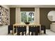 Modern dining room showcasing a wooden table, unique black chairs, and stylish wall decor at 11879 Brae Way, Dade City, FL 33525