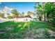 A spacious backyard with lush green grass, trees, partial privacy fence and a view of a pool at 12335 Yellow Rose Cir, Riverview, FL 33569