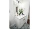 Bathroom vanity with quartz countertop, white cabinets, stylish fixtures, and patterned floor at 12335 Yellow Rose Cir, Riverview, FL 33569
