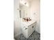 Modern bathroom vanity with white cabinets, a large mirror, and patterned flooring at 12335 Yellow Rose Cir, Riverview, FL 33569