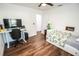 Bright bedroom showcases a modern desk setup and hardwood floors, offering a versatile living space at 12335 Yellow Rose Cir, Riverview, FL 33569
