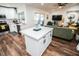 Modern kitchen featuring stainless appliances, white cabinetry, an island and adjacent living room at 12335 Yellow Rose Cir, Riverview, FL 33569