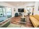 A bright living room featuring wood floors, comfortable seating, and sliding glass doors with pool view at 12335 Yellow Rose Cir, Riverview, FL 33569
