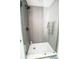 Modern shower featuring gray tile walls, white mosaic flooring, and glass door at 12335 Yellow Rose Cir, Riverview, FL 33569