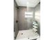 Modern shower featuring gray tiling, glass enclosure, and hexagon-patterned flooring at 12335 Yellow Rose Cir, Riverview, FL 33569