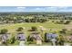 Expansive aerial of home with golf course, tree coverage and neighboring houses at 13514 Thoroughbred Dr, Dade City, FL 33525