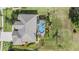 Aerial view of home, pool and spa area in backyard with mature landscaping at 13514 Thoroughbred Dr, Dade City, FL 33525