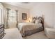 Cozy bedroom featuring a comfortable bed, window with curtains, and neutral decor at 13514 Thoroughbred Dr, Dade City, FL 33525