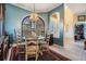 Elegant dining room with decorative chandelier, arched window, and tile flooring at 13514 Thoroughbred Dr, Dade City, FL 33525