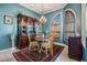 Cozy dining room with traditional furniture and large arched window with wooden shutters at 13514 Thoroughbred Dr, Dade City, FL 33525