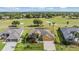 Stunning aerial view of a yellow home with a well-manicured lawn near a golf course at 13514 Thoroughbred Dr, Dade City, FL 33525