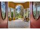 Elegant front porch with stone flooring and rocking chair, framed by decorative columns at 13514 Thoroughbred Dr, Dade City, FL 33525