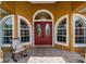 Close-up of the front entrance featuring double doors and charming rocking chair on the porch at 13514 Thoroughbred Dr, Dade City, FL 33525