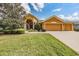 Charming single-story home with well-manicured lawn and three-car garage at 13514 Thoroughbred Dr, Dade City, FL 33525