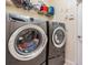 Modern laundry room with front-load washer and dryer, plus shelving at 13514 Thoroughbred Dr, Dade City, FL 33525