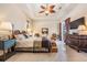 Spacious bedroom featuring a large bed, ceiling fan, and access to the outdoors at 13514 Thoroughbred Dr, Dade City, FL 33525