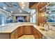 Open concept bar area with granite countertops, glass shelving, and views of entertainment area at 1408 Alhambra Dr, Apollo Beach, FL 33572