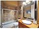 Neutral bathroom with a glass shower and vanity with a large decorative framed mirror at 1408 Alhambra Dr, Apollo Beach, FL 33572