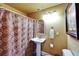 Comfortable bathroom featuring a pedestal sink, framed mirror and a shower with curtain at 1408 Alhambra Dr, Apollo Beach, FL 33572