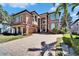 Stunning multi-story Mediterranean home with manicured lawn, brick driveway, and barrel tile roof at 1408 Alhambra Dr, Apollo Beach, FL 33572