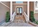 Elegant front entrance featuring double doors, stone staircase and manicured landscaping at 1408 Alhambra Dr, Apollo Beach, FL 33572
