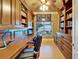 Office with custom built-in shelving and cabinets, a ceiling fan, and a large window at 1408 Alhambra Dr, Apollo Beach, FL 33572