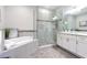Modern bathroom with a glass-enclosed shower, soaking tub, and granite countertops at 16 Franklin S Ct # A, St Petersburg, FL 33711