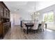 Elegant dining room with a modern chandelier, wood-look tile, and a large window at 16 Franklin S Ct # A, St Petersburg, FL 33711