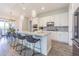 Modern kitchen island with bar stool seating and stainless appliances adjacent to the dining area at 16 Franklin S Ct # A, St Petersburg, FL 33711