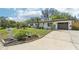 Exterior shot of house with a well-manicured front yard and a neatly paved driveway leading to the garage at 1632 Clearview Ave, Clearwater, FL 33756