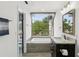 Bathroom with a tub beneath a large window, providing ample natural light and a view to the outside at 170 E Davis Blvd, Tampa, FL 33606