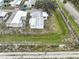 The aerial shot highlights the mobile home with its metal roof, surrounded by grass and a small fence at 1710 7Th Sw St # 95, Ruskin, FL 33570