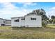 Home's exterior with white siding, awnings, and manicured lawn at 1710 7Th Sw St # 95, Ruskin, FL 33570