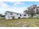 Exterior view of home with white siding, awnings, and a landscaped yard at 1710 7Th Sw St # 95, Ruskin, FL 33570
