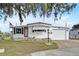 Charming single-story home featuring a tidy front yard, garage, and classic white exterior at 1710 7Th Sw St # 95, Ruskin, FL 33570