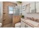 Bathroom features a tiled shower, glass block window, tiled floor, and a vanity with granite countertop at 1808 Gray S St, Gulfport, FL 33707